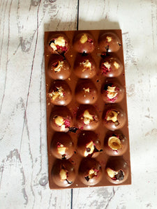 Handmade artisan chocolate bar with juicy fruit and roasted hazelnuts